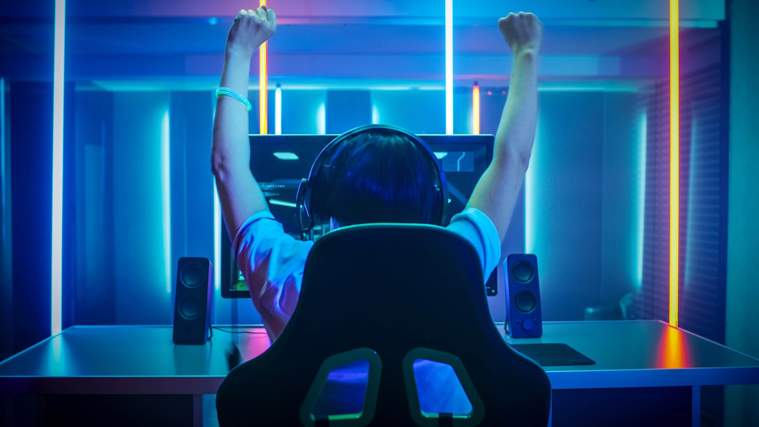 seorang gamers dengan headset sedang berhadapan dengan PC